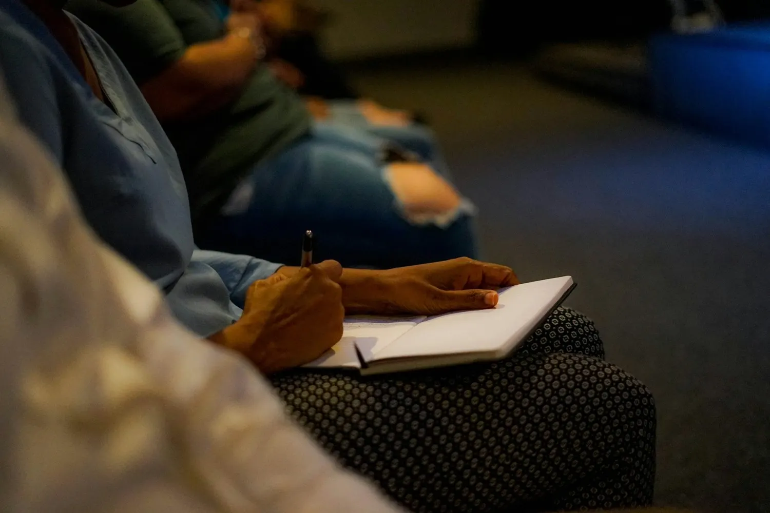 Person taking notes during a meeting or church gathering.