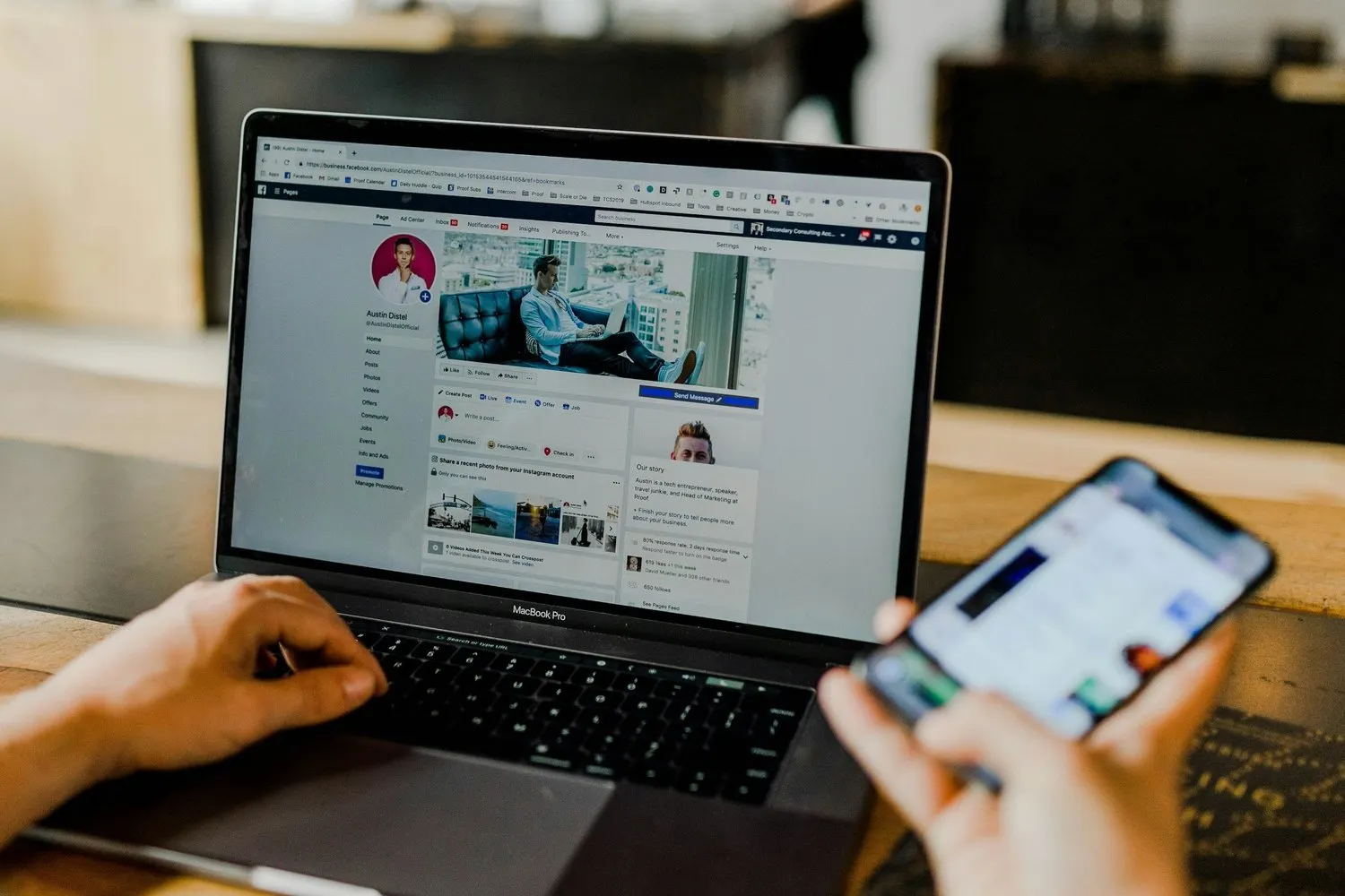 Person using a laptop and smartphone to manage social media.