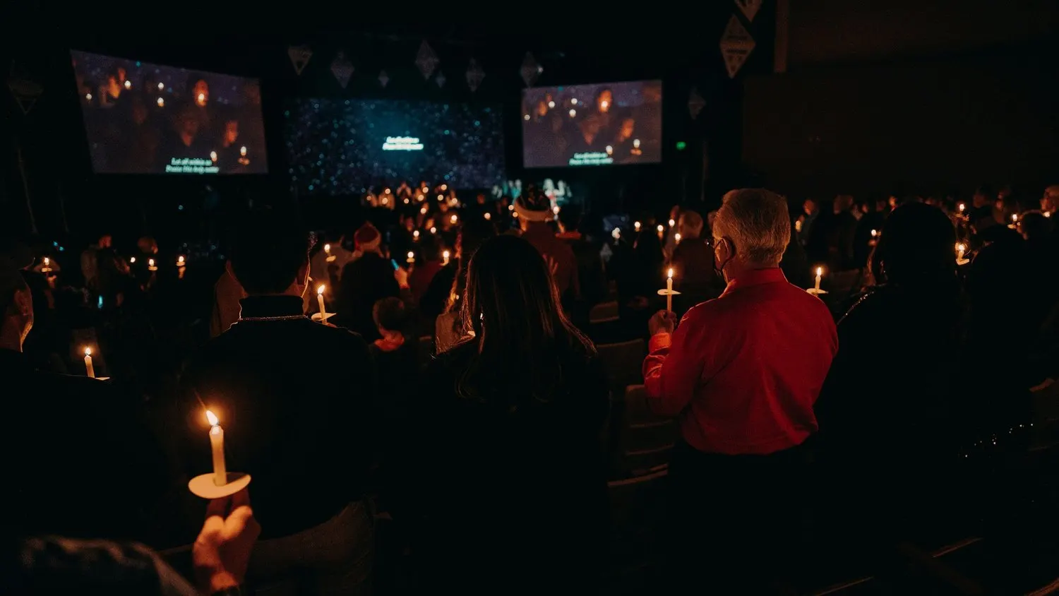 Congregation holding candles during a church worship service.